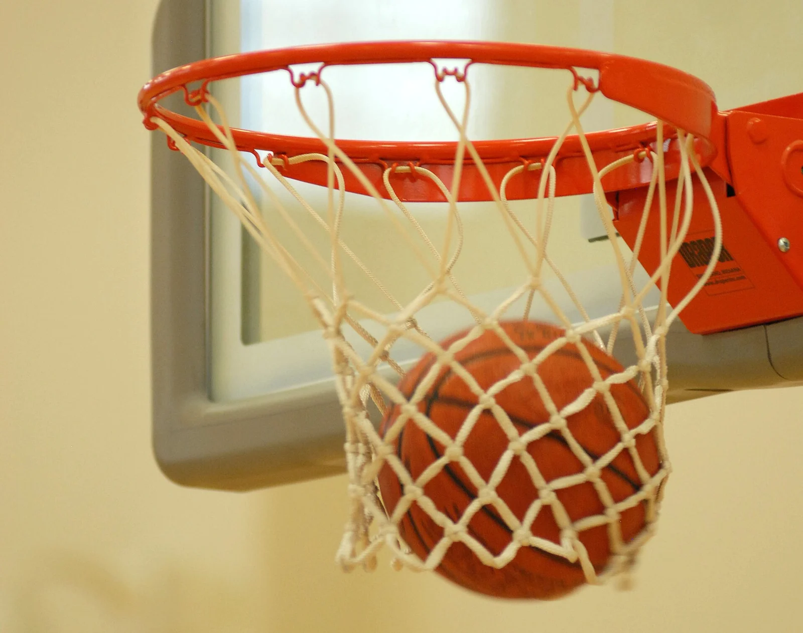Ein Basketball fällt durch das Netz eines roten Korbrings.