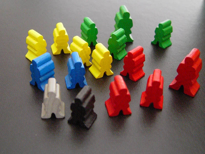 Farbige Holzfiguren in Menschenform als Arbeiter des Spiels.